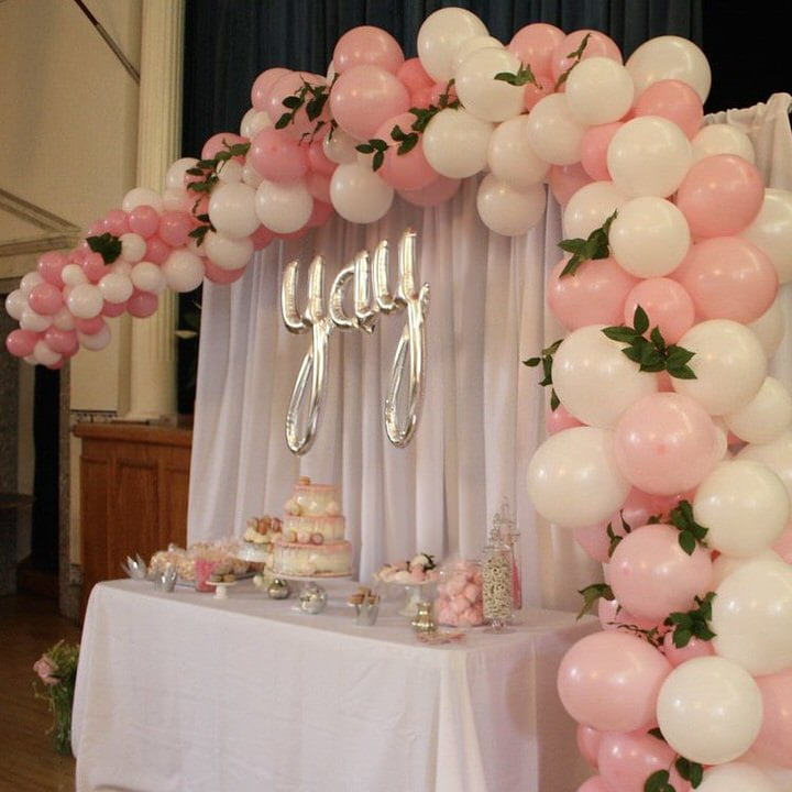pink and white balloon arch over table