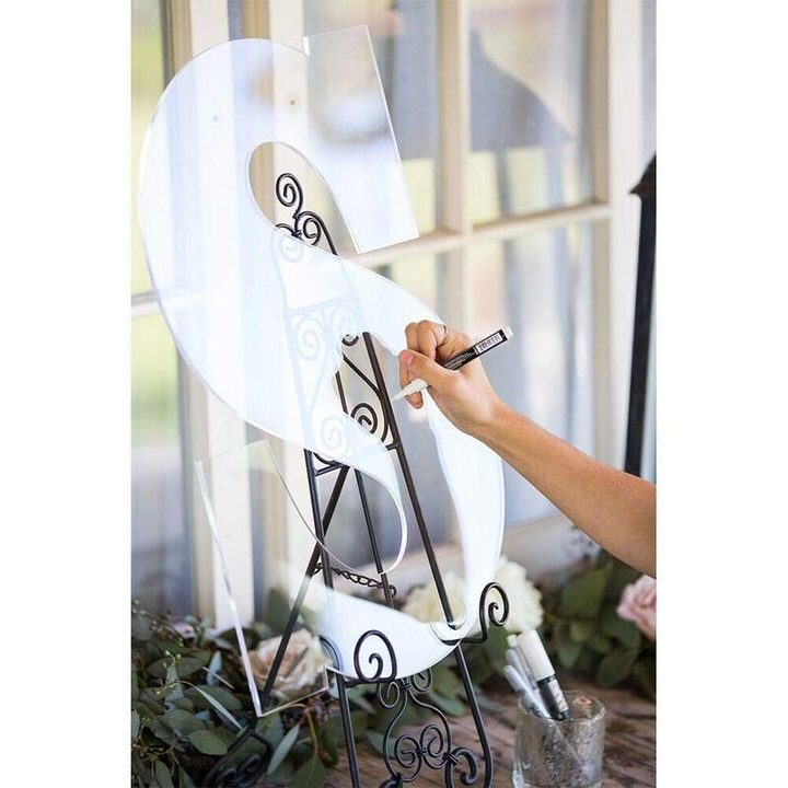 Lady signing clear acrylic letter guest book on black easel