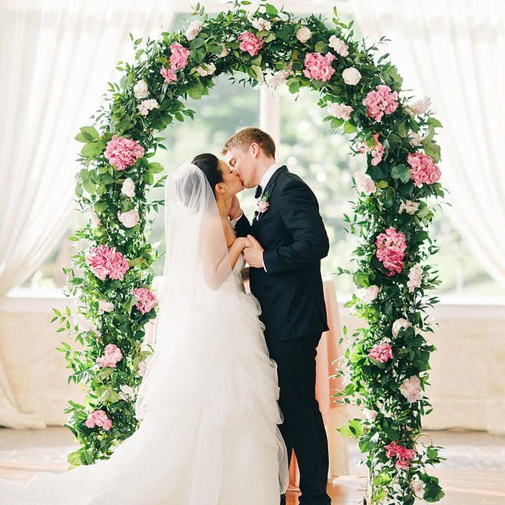 pink & green Flower Arch with wedding couple kissing