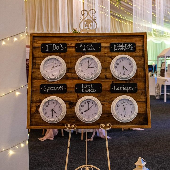Wooden Order of The Day Sign with white clocks on cream easel