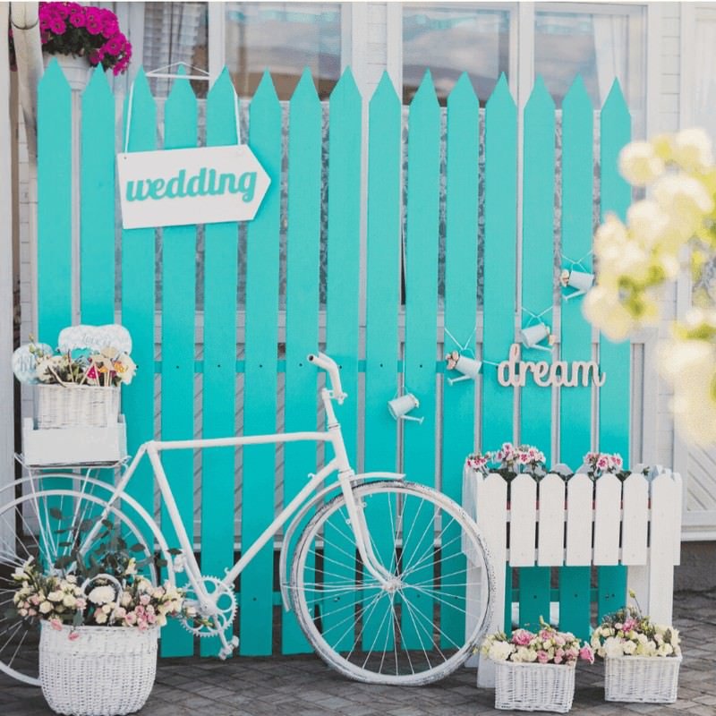 turquoise wood fence with white bike & flowers