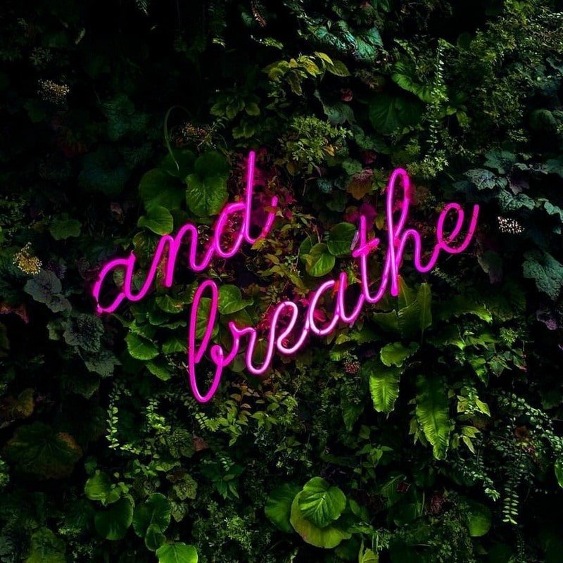 and breathe purple neon sign